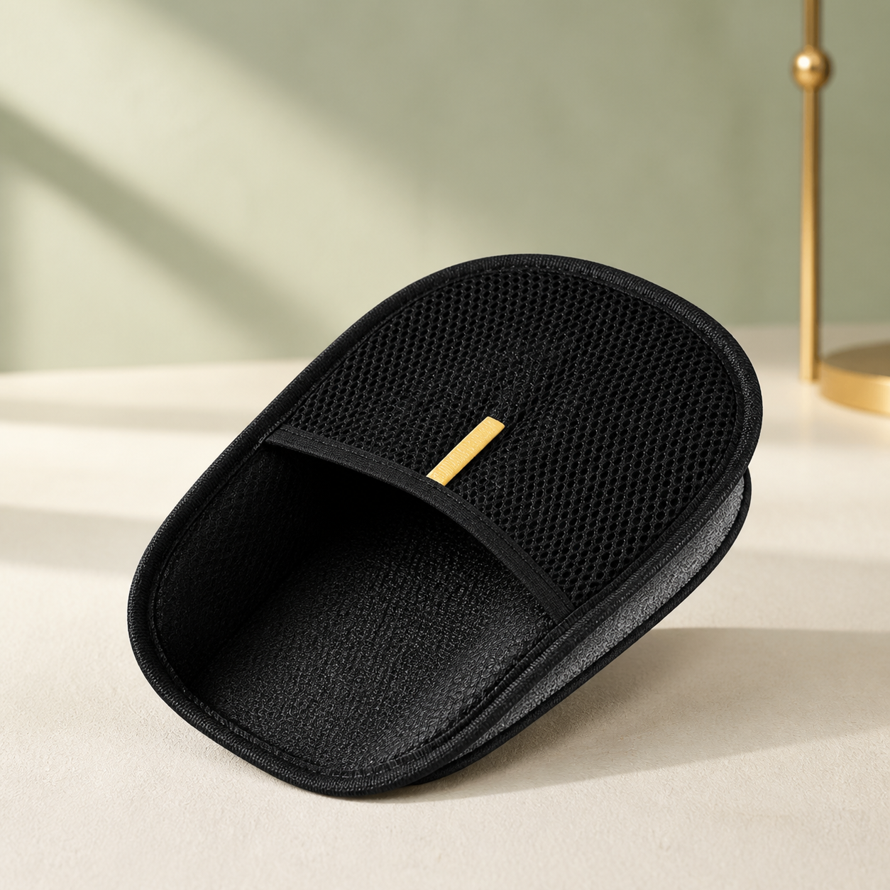 Black FurLift reusable pet-hair mitt displayed on a warm white studio surface